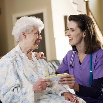 A woman patient and woman HCP are talking. The HCP's hand is placed on the woman's shoulder. 