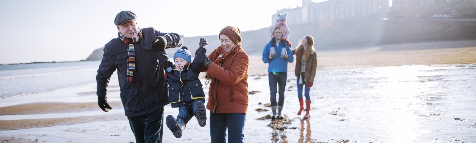 Multi- Generation Family Walking Along the Beach